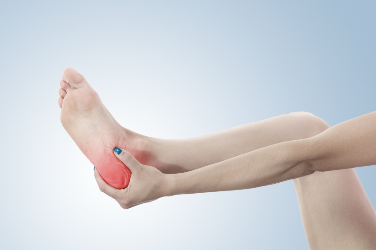 Person holding their heel in pain during a telehealth visit